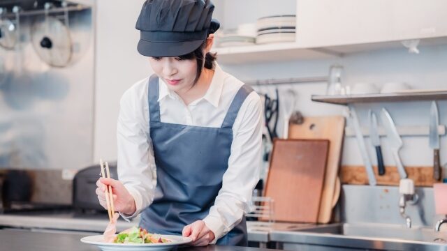 レストランのキッチンで盛り付け作業するスタッフ