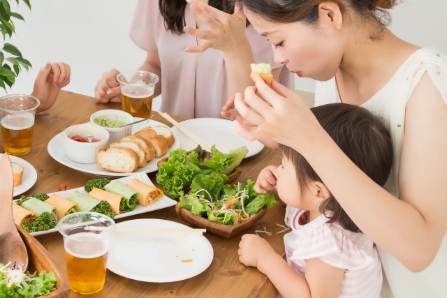 子どもと野菜料理で食事する母親