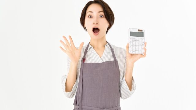 電卓を持ち家計が苦しい女性のイメージ